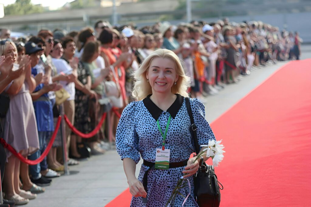 a woman is walking down a red carpet, russian women's rights