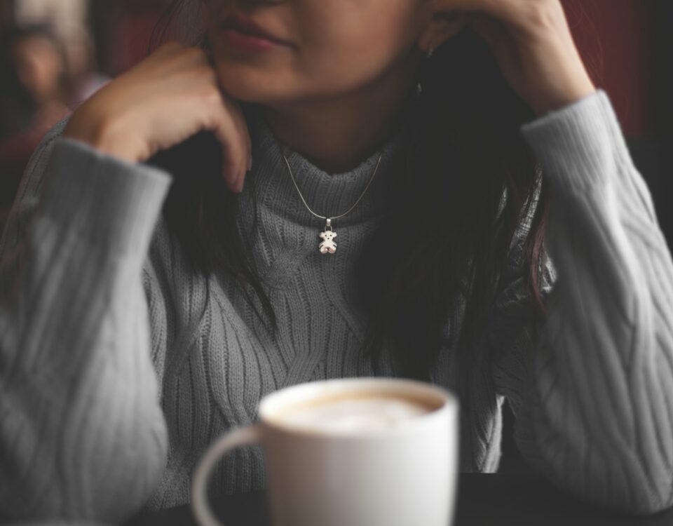 cup of coffee in front of woman